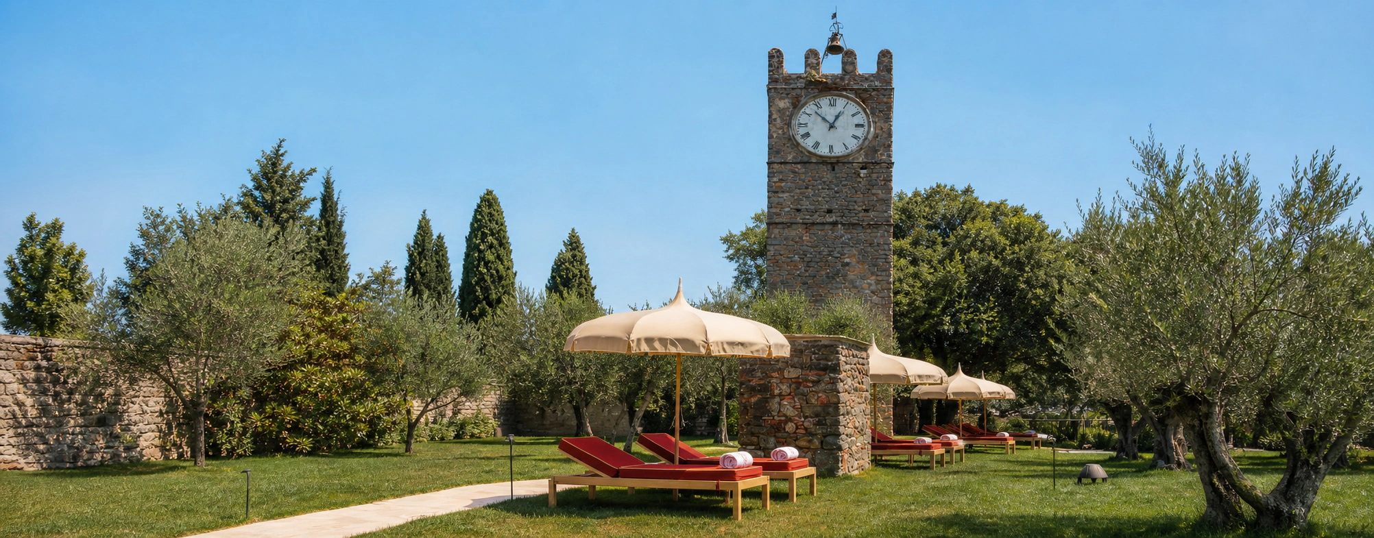 Giardino toscano con torre storica, ombrelloni e lettini Toscano Forme